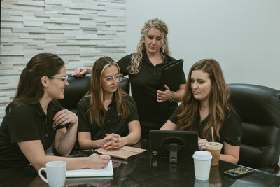 four women sitting around a table working