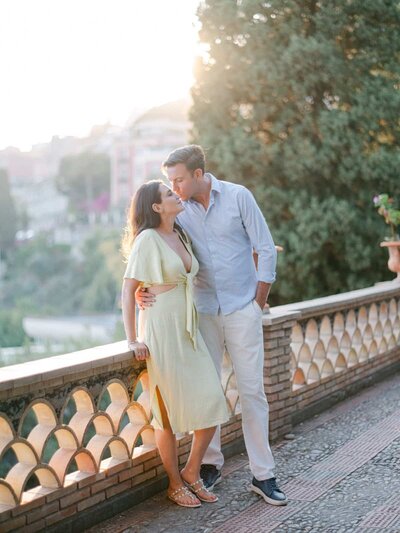 Romantic engagement session at golden hour overlooking Taormina, with a couple sharing a tender moment — Portfolio Thomas Raboteur Wedding Photographer.