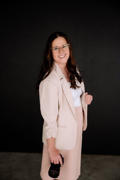Lubbock Senior Photographer posed in a creme blazer, white tank and a pastel pink pencil skirt.