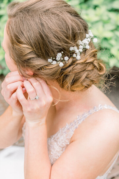 bridal portrait of bride putting on earrings before her wedding