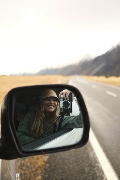 Eilish Burt takes a photograph in the wing mirror of a car