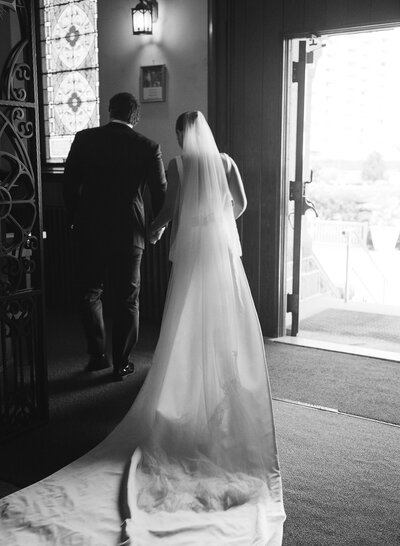 Close up view of delicate wedding dress skirt, wedding bouquet, and heels