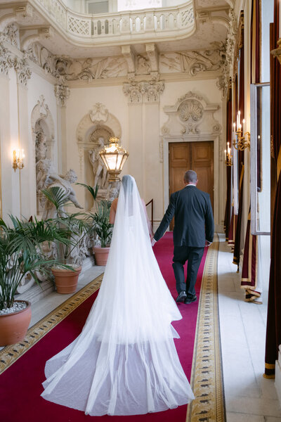 Destination wedding couple walking through the hallways of majestic palace Daun Kinsky in Vinna