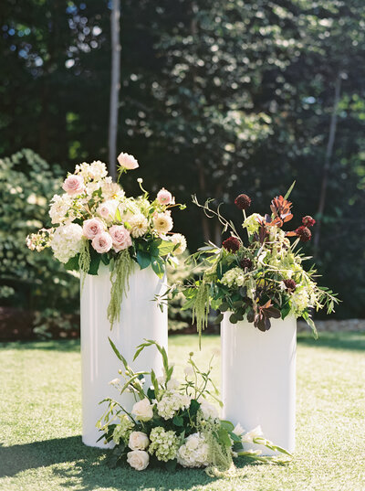 soft pink crystal glasses with floral pattern linens and plates, and yellow blue and pink florals arrangements designed by Sirpilla Soirees, Wedding Planners in Cleveland Ohio