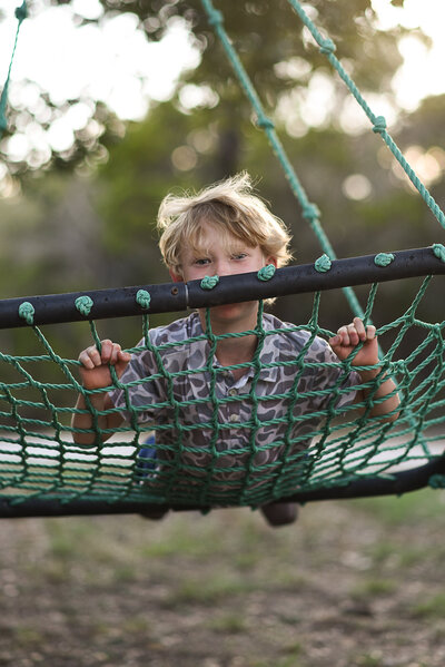 Girl looks up at her red roan horse at sunset