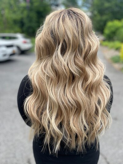 Photo of the back of a blonde haired client with long hair and extensions