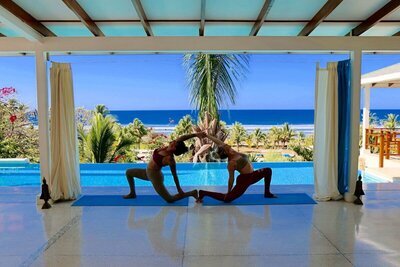 Students practicing yoga in a tropical setting in Costa Rica with Soma Yoga Institute.