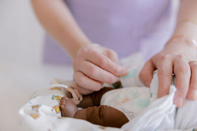 Neonatal therapist changing diaper of NICU baby