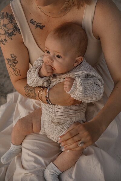 mom holds baby on beach for family photos