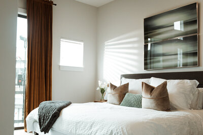 a bed with calming green and neutral bedding