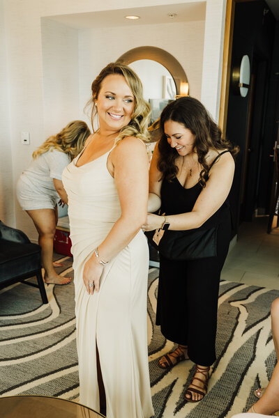 Coordinator helping bridesmaid intro dress
