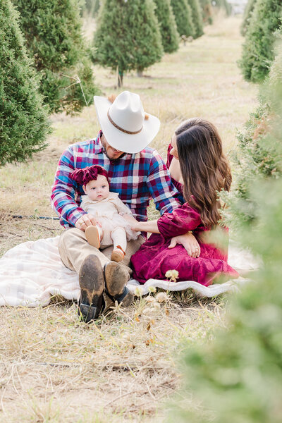 Family at tree farm with red, black and green on