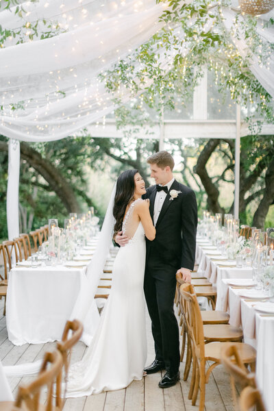 bride and groom in bridal gown standing in tented reception space outdoors wedding