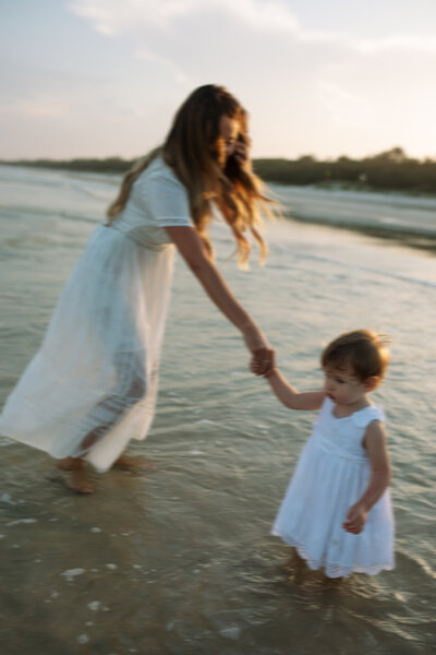 A mum and toddler playing in the waves at Dreamtime beach , Fingal