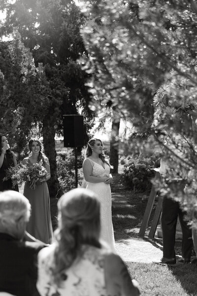 bride looks at her groom at the alter, listening to his vows at this alberta elopement