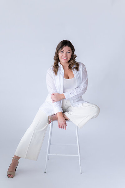Sarah Hawk posing on white chair, educator and designer