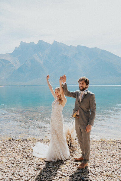 A recently wed couple taking in the view after a sunrise ceremony in Lake Louise