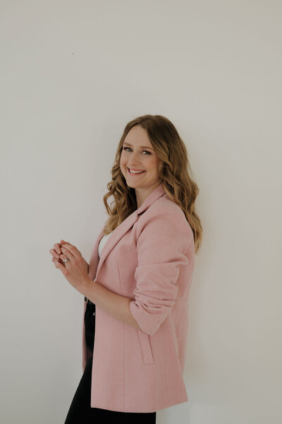 Liz, event planner milwaukee
 and founder of Dream Weddings WI, turned to the left while holding her hands together.