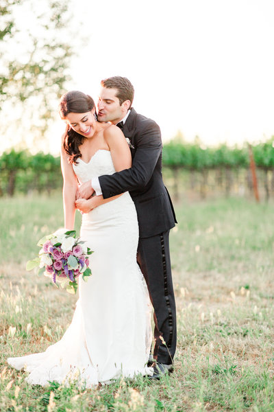 a bride sitting in a chair with soft glowing light putting on her perfume