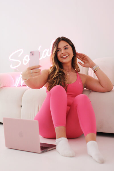 Pink dress and heels- social media manager on the laptop