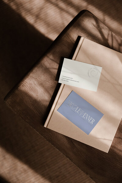 Nicole Venner’s business cards on a textured surface, featuring contact details and a logo with the text 'Nicole Venner' in elegant script.