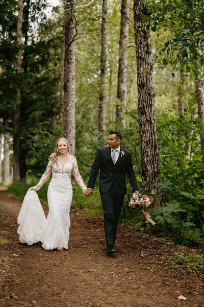Bride and groom walk holding hands in Portage, Alaska
