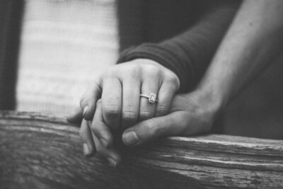 couple holding hands engagement ring black and white