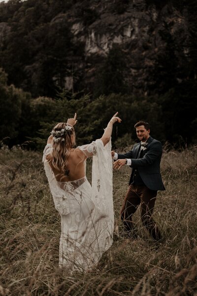 bride and groom dancing in field