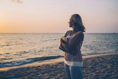 Woman on the beach looking out at the ocean