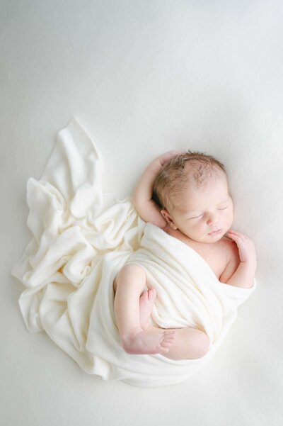 newbornshoot baby jongen in wit doek gewikkeld