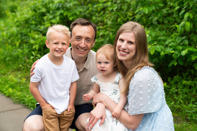 Family of four laughing together during their family photos