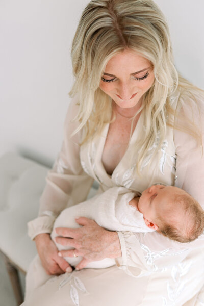 Elegantes Babybauchfoto im Negligee beim Schwangerschaftsshooting. Das Babybauchshooting ist stilvoll in hellen und zarten Tönen gehalten.