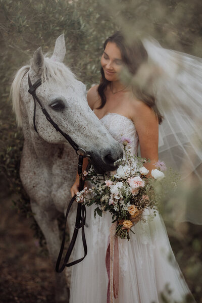 Bride with horse holding blush bridal bouquet