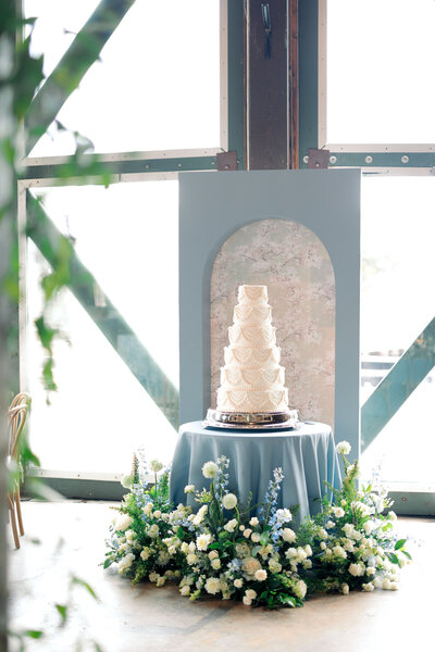 Black backdrop with white flowers and green foliage.