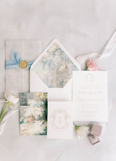 Wedding invitations with ring box and flowers.