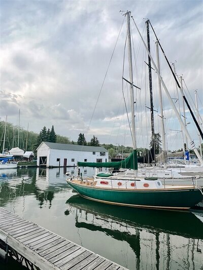 view of a green sailboat stern in a marina on the glassy waters of Lake Superior