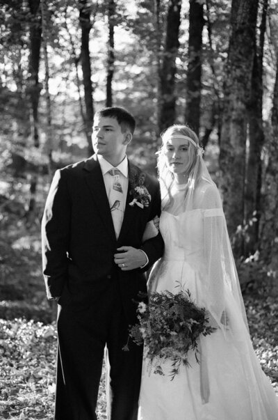 Vermont vintage bride and groom standing in the sun together in the woods