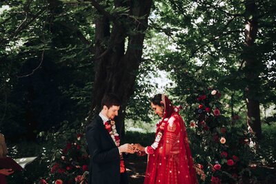 Couple exchanging rings at their luxury forest wedding ceremony in Cambridge