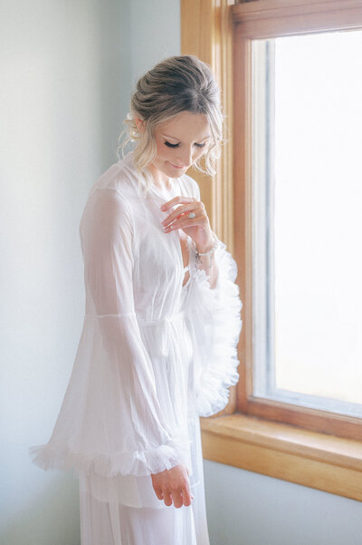 bride in robe by window near Omaha Nebraska