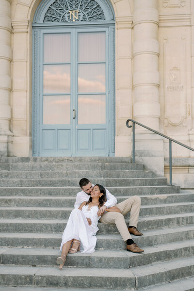 image of a couple posing for their engagement session outside the Chateau Du Sceaux stairs in Paris