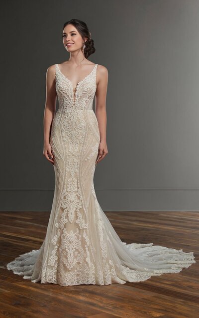 LINEAR LACE WEDDING DRESS This linear lace wedding dress is a unique and amazing addition to the Martina Liana wedding dress collection! A deep V-neckline is the focal point of this gown’s bodice, highlighted beautifully with chunky bugle beads and pearls. A mix of linear lace and romantic lace motifs are mixed throughout the gown, giving it an artful feeling that also sculpts the body. The deep V-back of this gown features linear detailing, which only adds to the uniqueness of the style. The gown’s long, wide train features multiple layers of tulle, creating a light-as-air look adorned with lace appliques. The back of this linear lace wedding dress zips up beneath crystal buttons.