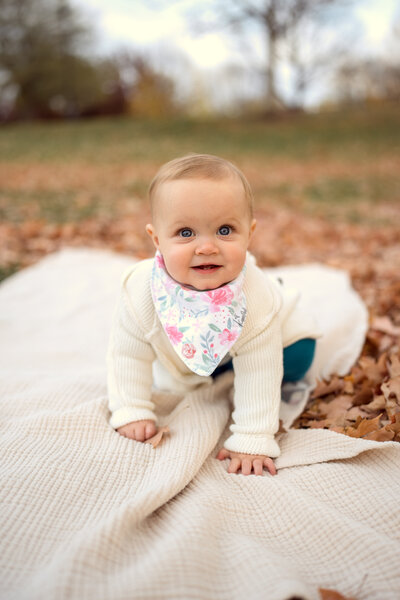 A small baby crawling with fall leaf's behind her at Libby Hill Park in Richmond Virginia/