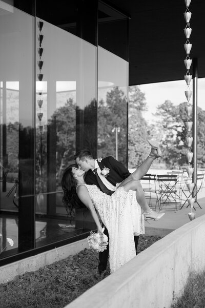 A bride rests her head on her fiancé's shoulder, looking at the camera while he looks away. Her hand is also on his shoulder, showing her beautiful engagement ring.