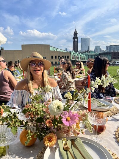 Guests enjoying a luxury picnic with floral centerpieces and city views, styled by Yours Truly, a wedding planner and designer in New Jersey.