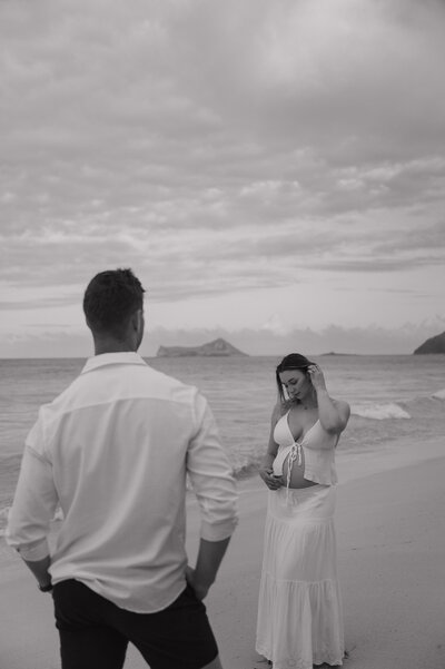 Man and woman converse on the ocean shore in Hawaii