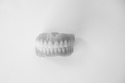 A set of dentures created by Kalispell Denture Studio  sits on a white background.