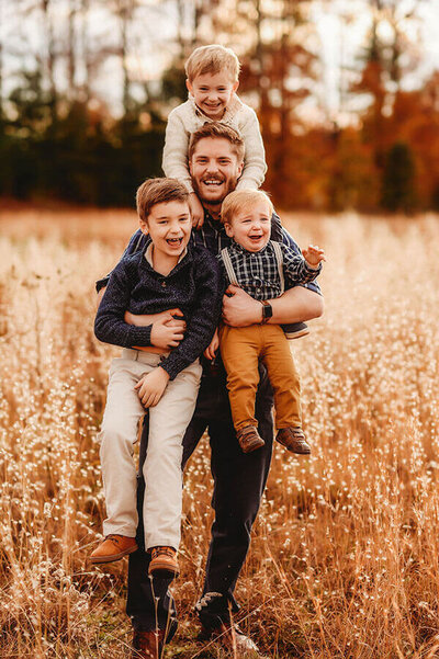 Father holds his sons during Family Photoshoot in Asheville, NC.