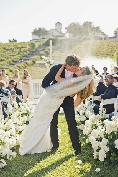 couple's first kiss at outdoor wedding