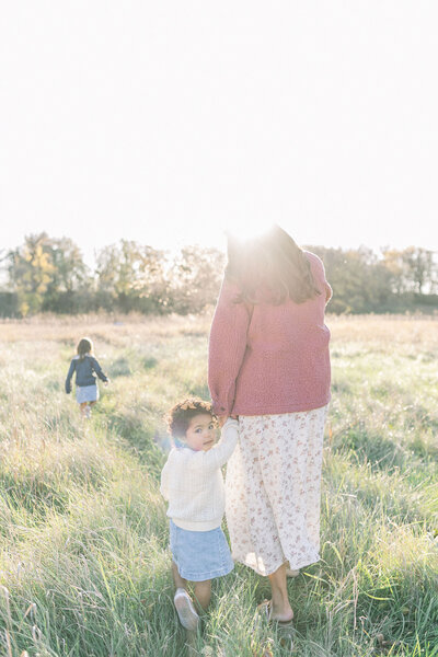 A family sitting on the floor smiling at each other during their Grand Forks photo session with Chelsea Nichole Photography. 