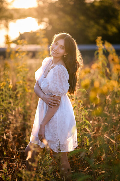 High School senior girl standing in a field.